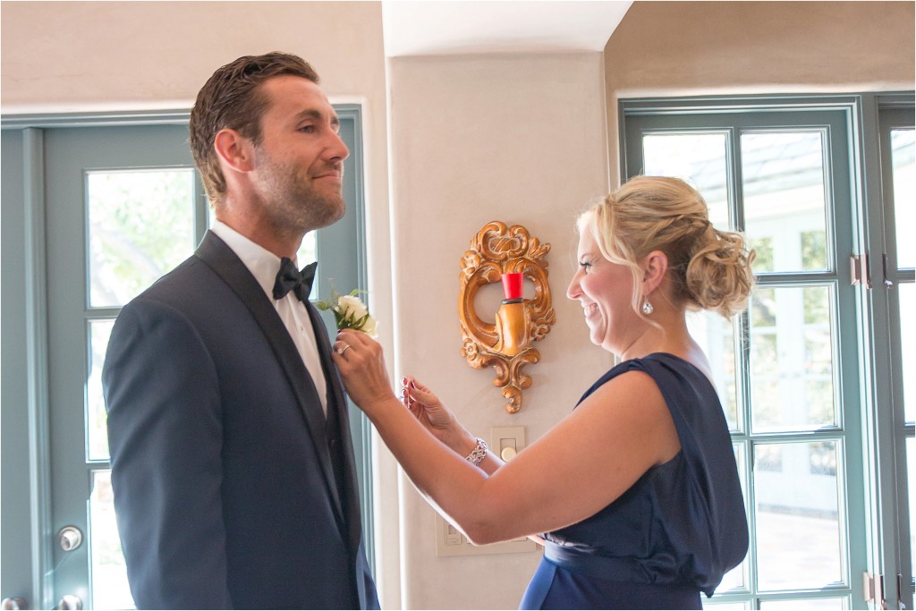 mother pinning groom boutonniere