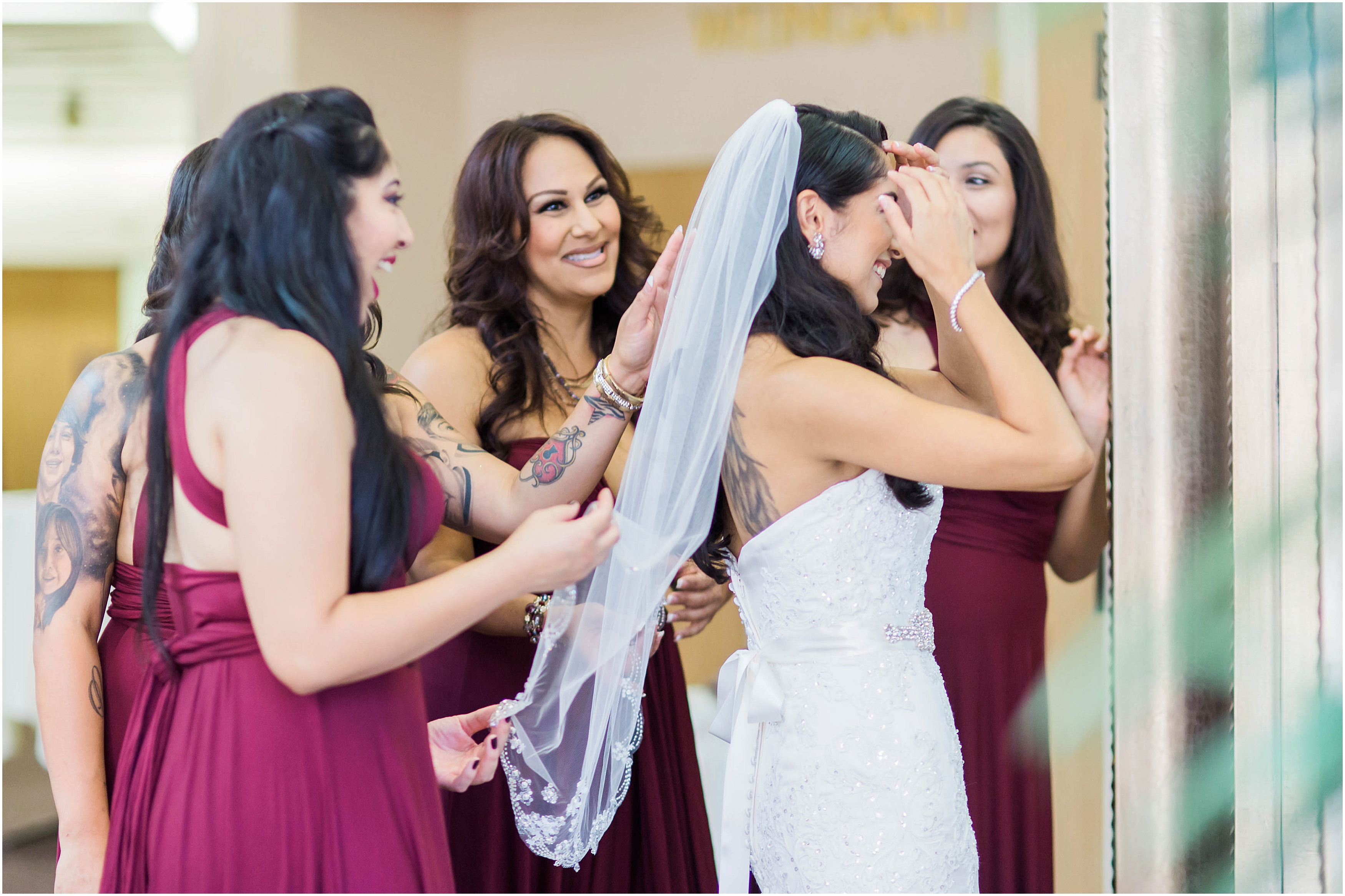 bridesmaids assisting bride with veil