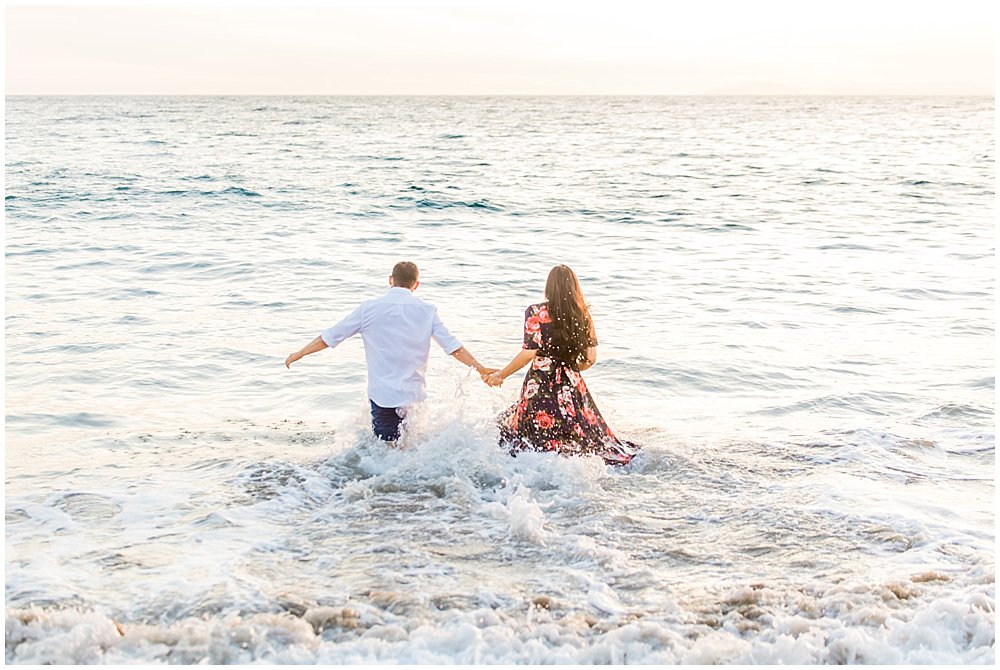 Couple takes a dip in the ocean during engagement photos at Laguna Beach
