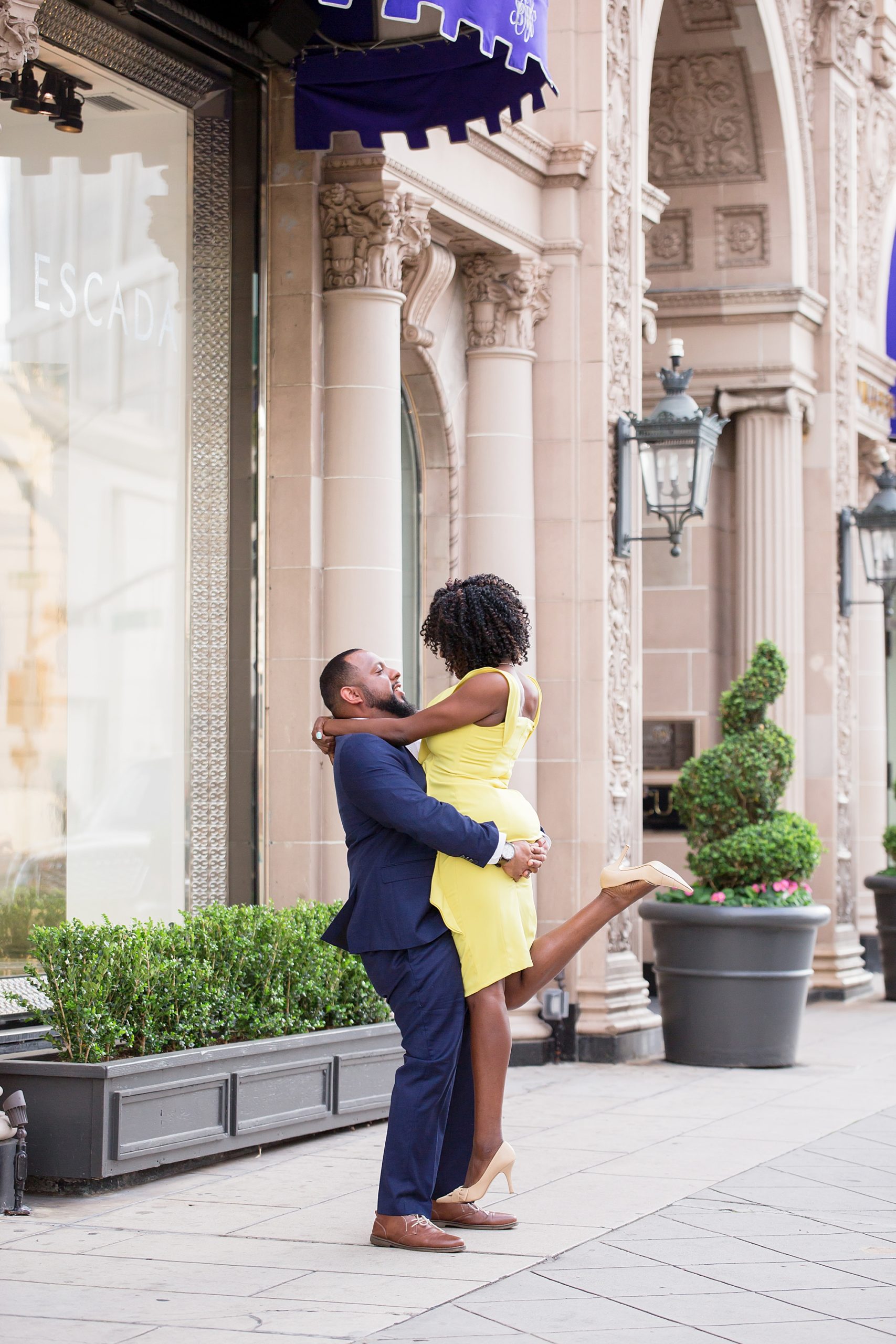 Beverly Wilshire Hotel engagement photos groom lifts his fiance in celebration