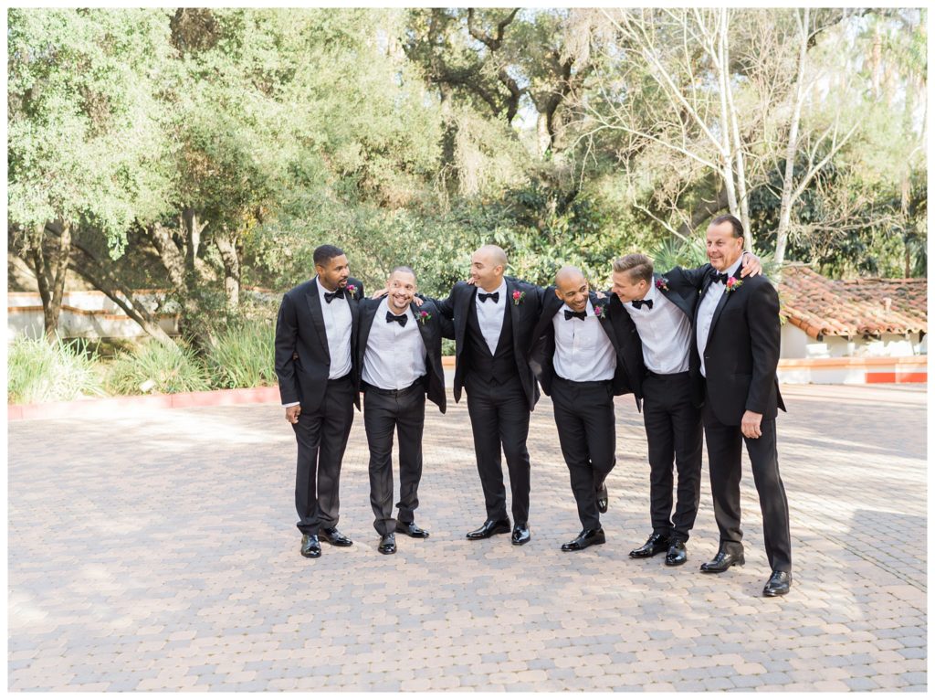 groomsman pose with arms around one another