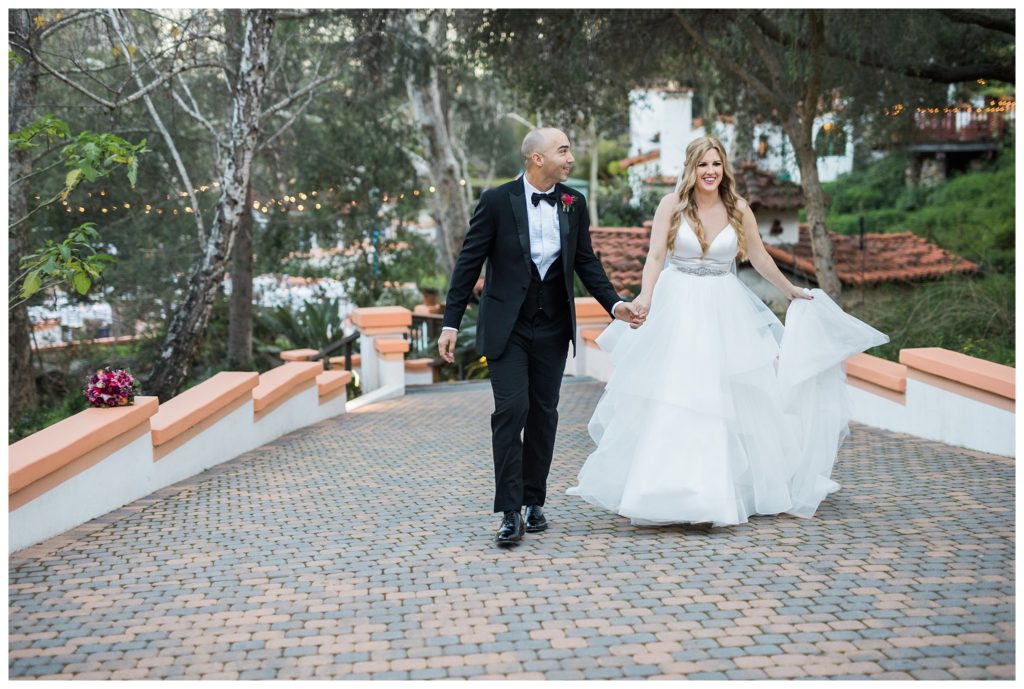 bride and groom walking holding hands on brick road