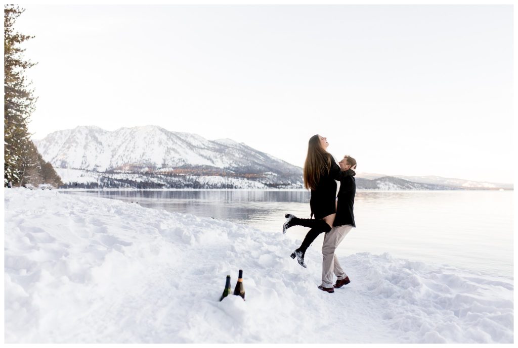 man and woman dancing in snow by lake tahoe