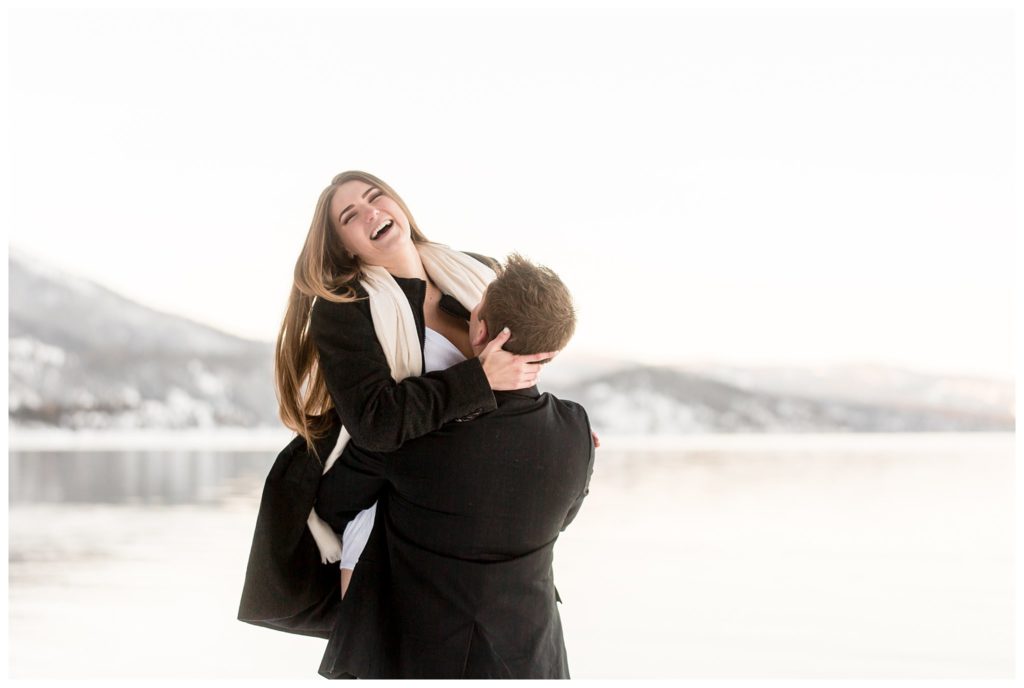 man lifts woman smiling in lake tahoe