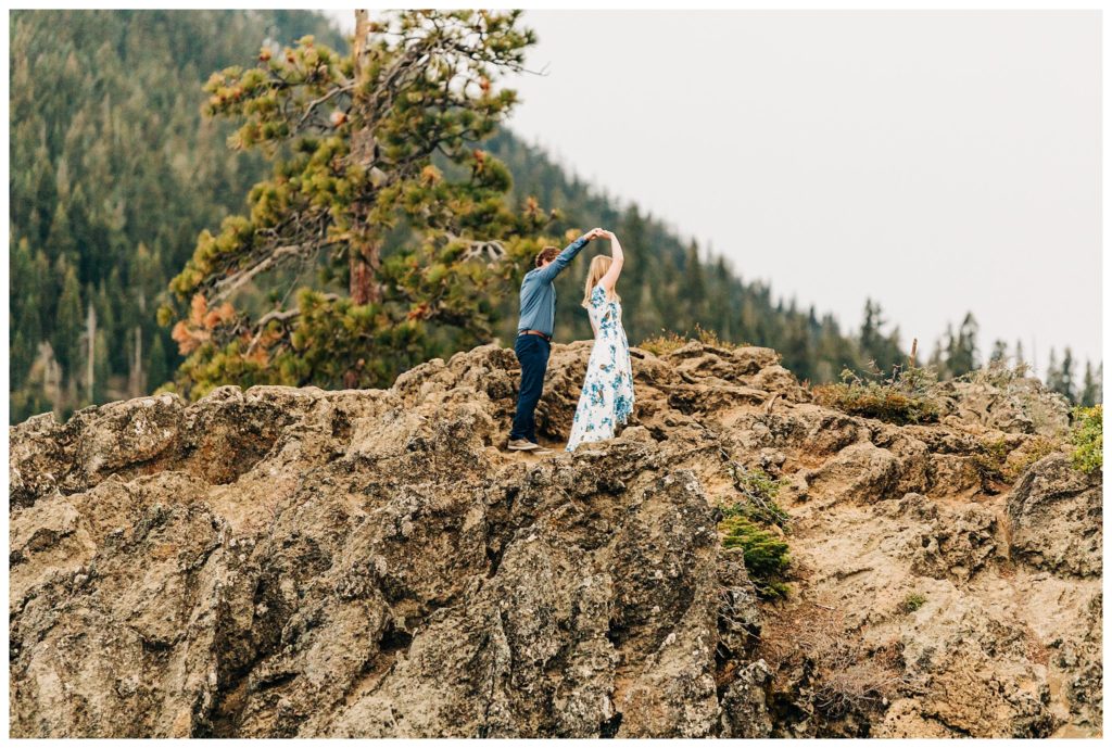 man twirling woman on eagle rock near lake tahoe
