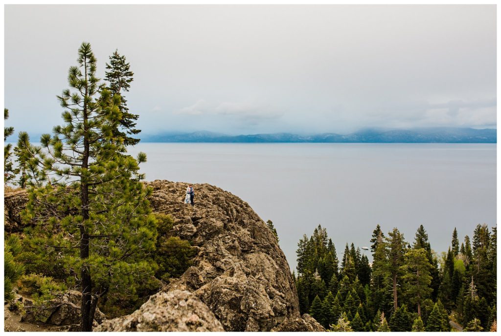 couple kissing on cliff by lake tahoe