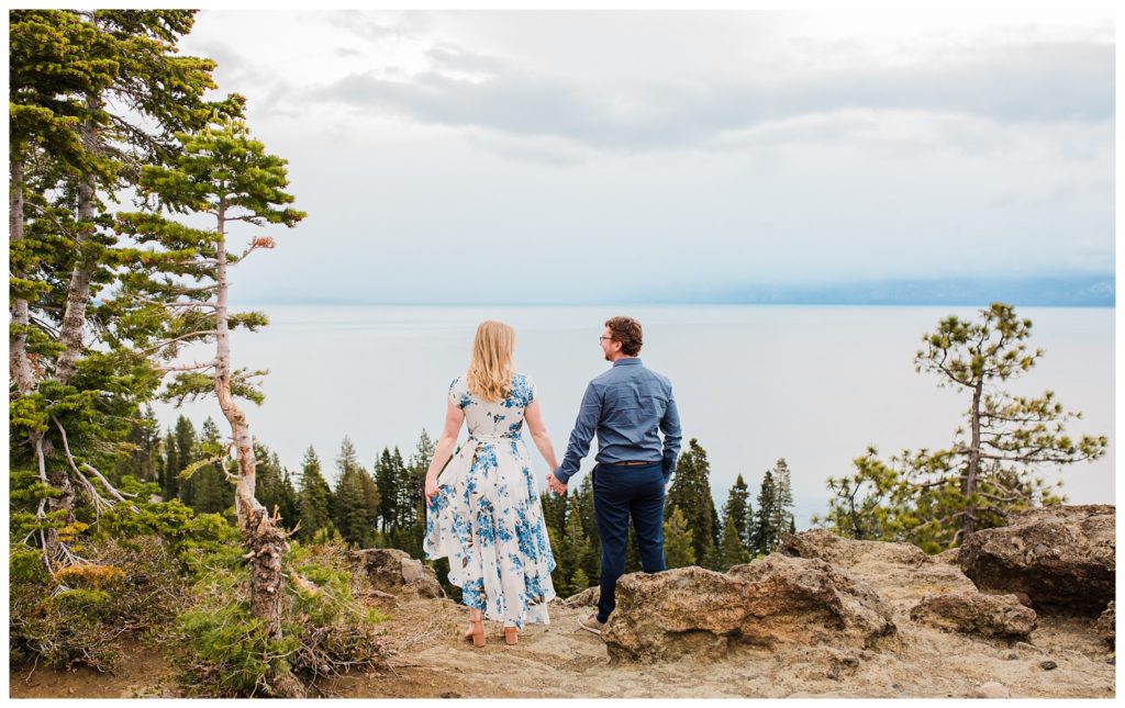 couple holding hands looking out on lake tahoe