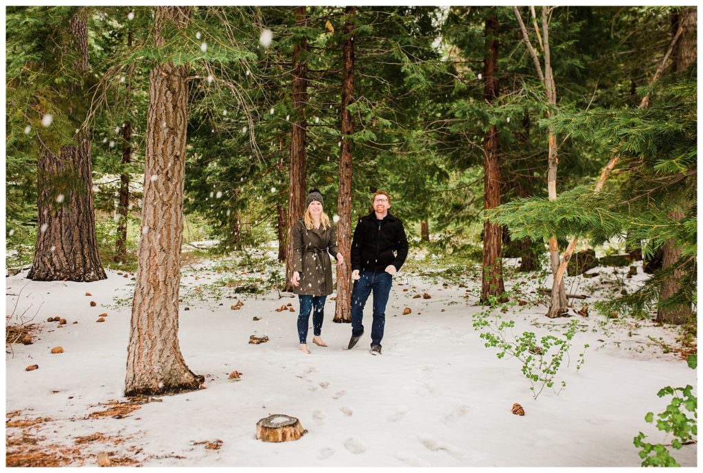 couple throwing snowballs in forest