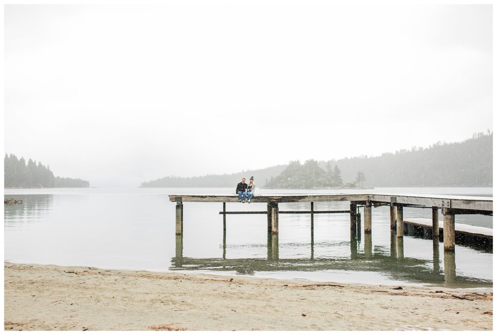 couple sitting on pier by emerald bay