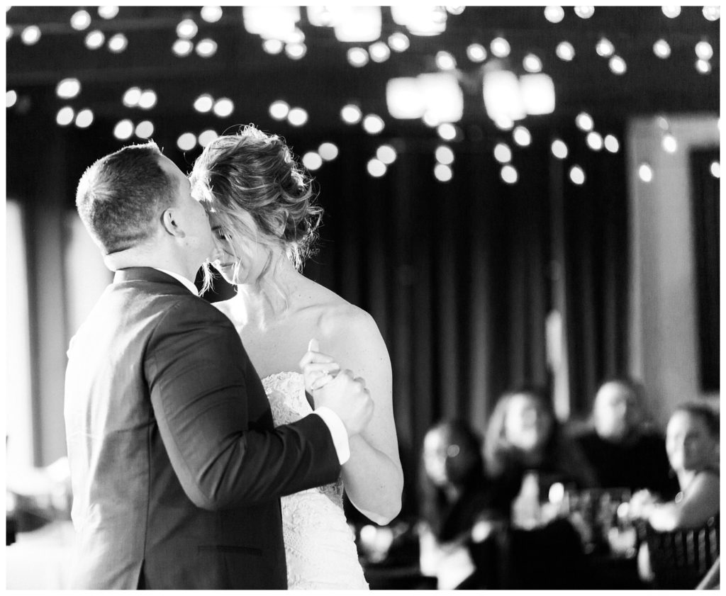 husband kissing wife on forehead during first dance