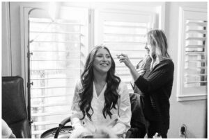 black and white image of bride getting her makeup done