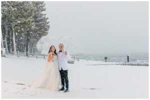 couple posing on the beach for winter lake tahoe wedding