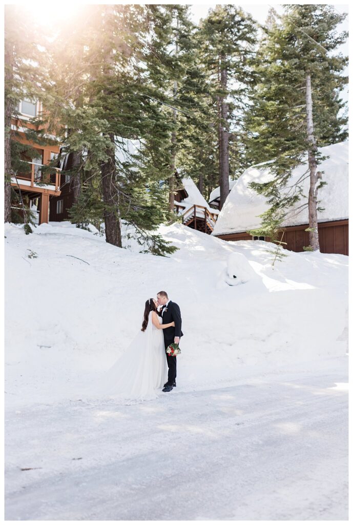 lake tahoe wedding couple kissing in the snow in front of their cabin