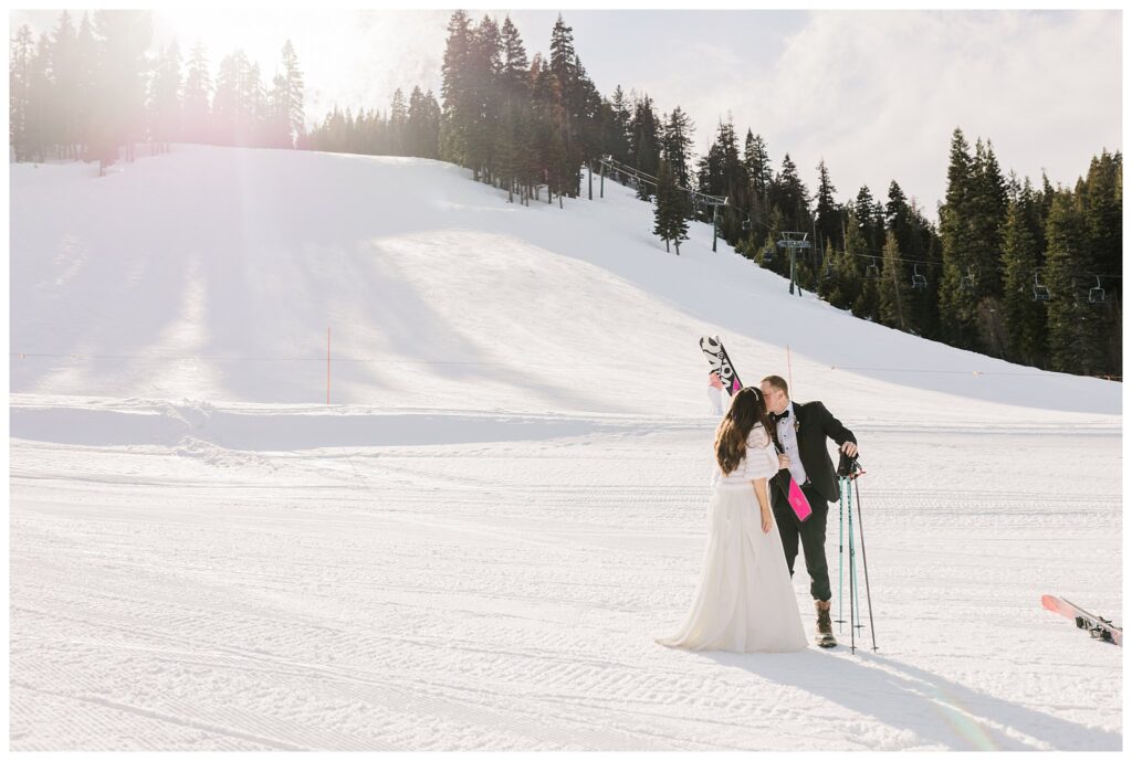 couple kissing in the snow with skis at homewood resort
