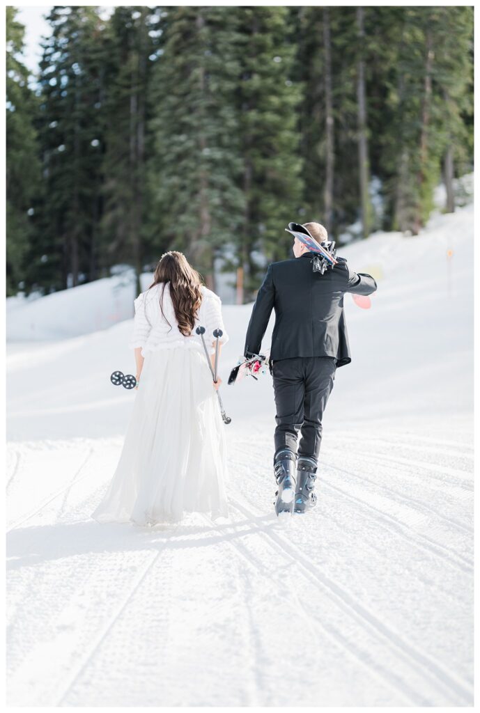 lake tahoe wedding couple carrying skis on snow trail at the homewood resort