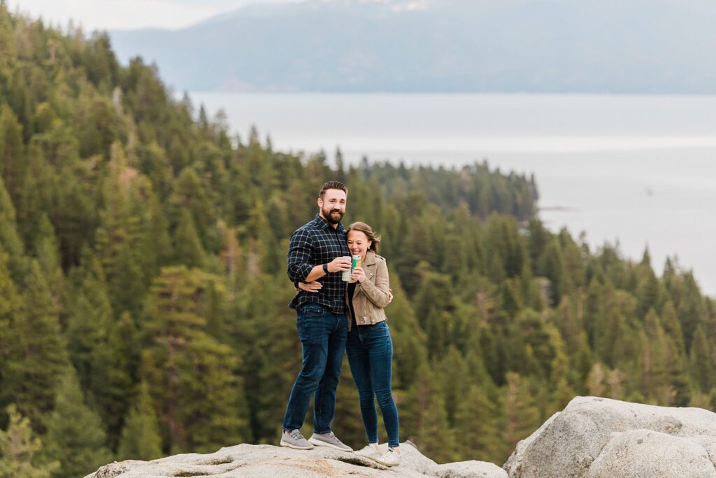 A couple standing on top of emerald bay overlooking lake tahoe.