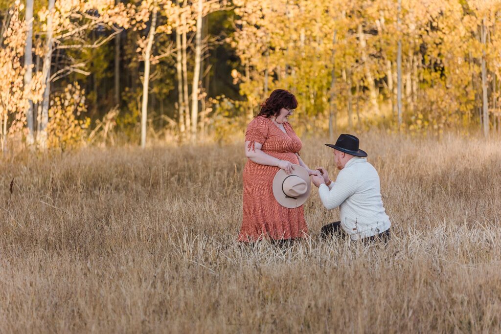 A couple embracing in a meadow surrounded by trees during their Lake Tahoe fall engagement photography session.